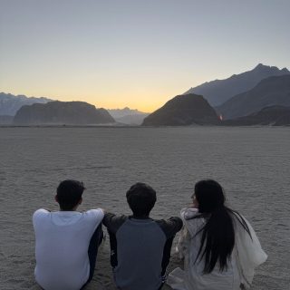 Golden sand dunes and rugged terrain of Safaranga Desert under a clear sky